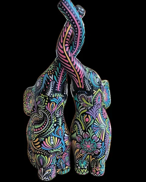 Dos gatos de cerámica abrazados con las colas entrelazadas, pintados en colores